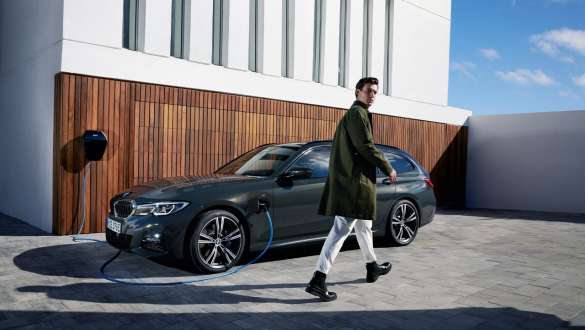 Plug-in-Hybrid BMW 3er Touring 2021 (G21) Dreiviertel-Seitenansicht an BMW Wallbox Plug-in-Hybrid BMW 3er Touring 2021 (G21) Dreiviertel-Seitenansicht an BMW Wallbox mit Model