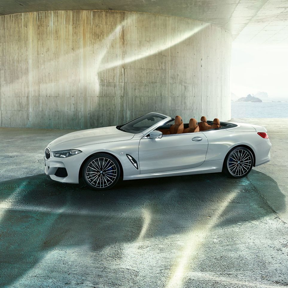 BMW M850i xDrive in Mineralweiß metallic, Seitenansicht mit geöffnetem Stoffverdeck. BMW M850i xDrive in Mineralweiß metallic, Seitenansicht mit geöffnetem Stoffverdeck.