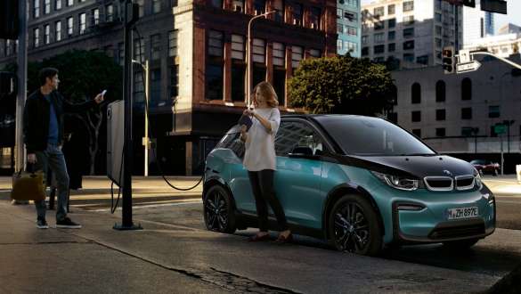 BMW i3 2018 an einer öffentlichen Ladestation Jucarobeige mit Akzent Frozen Grey metallic Paar lädt seinen BMW i3 an einer öffentlichen Ladestation I01 2018 Jucarobeige mit Akzent Frozen Grey metallic