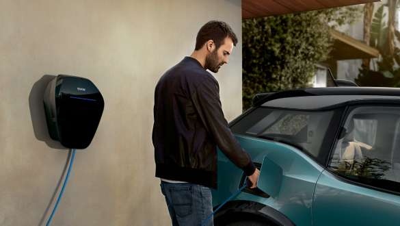 Mann lädt seinen BMW i3 2018 an BMW Wallbox Mann mit BMW Wallbox Ladekabel BMW i3 I01 2018 Jucarobeige mit Akzent Frozen Grey metallic