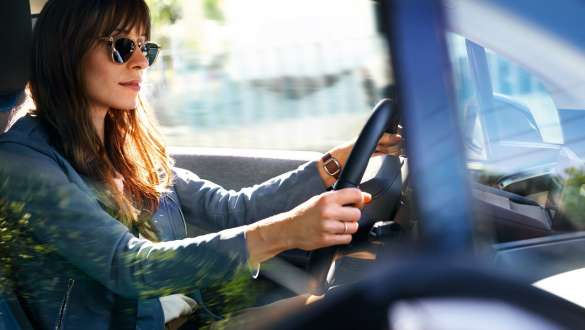 Frau mit Sonnenbrille fährt einen BMW i3 Frau mit Sonnenbrille fährt einen BMW i3
