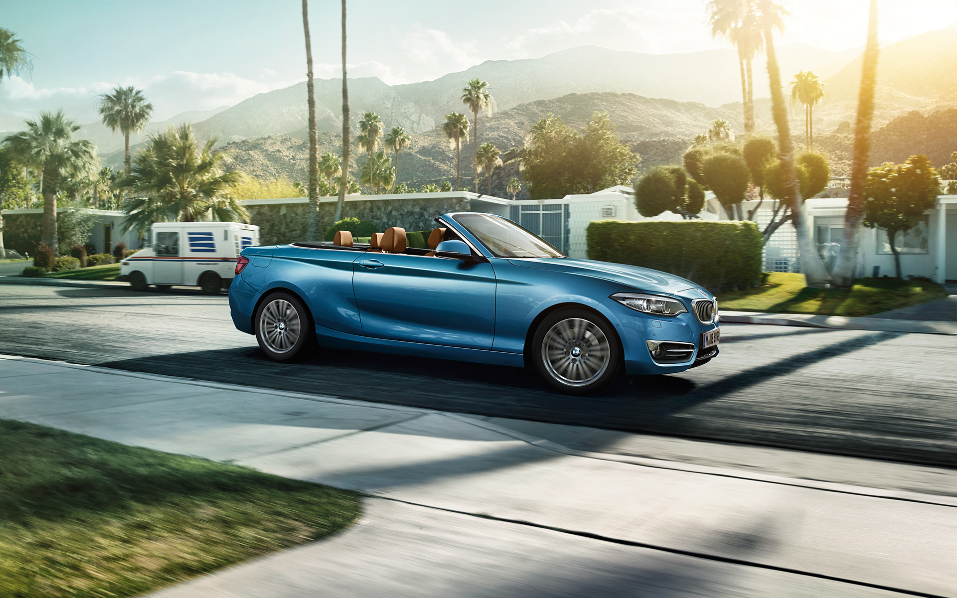Blaues BMW 2er Cabrio fährt durch eine Wohngegend, Seitenansicht, schöne Landschaft im Hintergrund Blaues BMW 2er Cabrio fährt durch eine Wohngegend, Seitenansicht, schöne Landschaft im Hintergrund