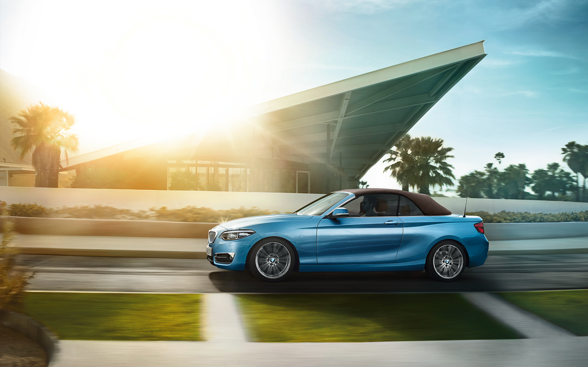 2er BMW Cabrio fährt an einem modernen Haus vorbei 2er BMW Cabrio fährt an einem modernen Haus vorbei