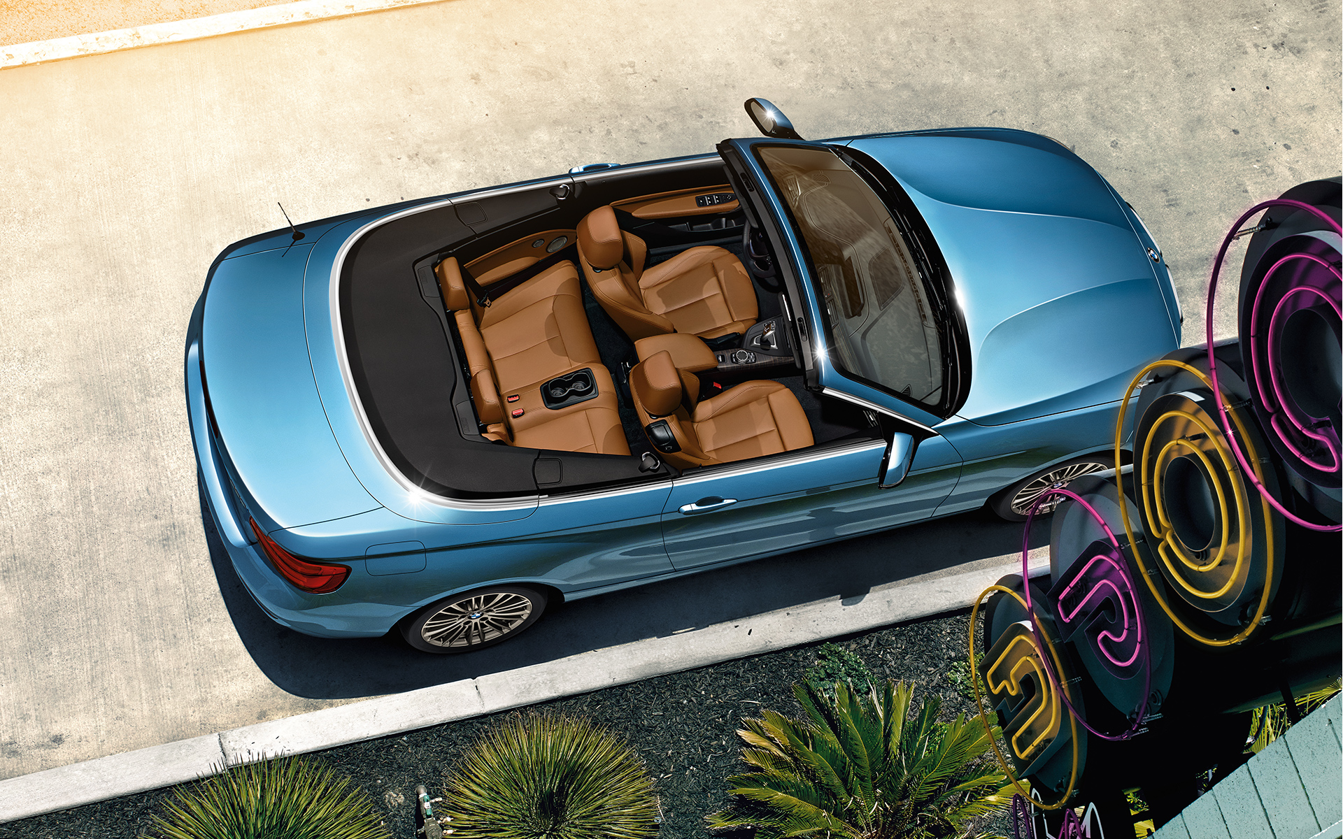 Blick von oben auf ein blaues BMW 2er Cabrio mit braunen Ledersitzen Blick von oben auf ein blaues BMW 2er Cabrio mit braunen Ledersitzen