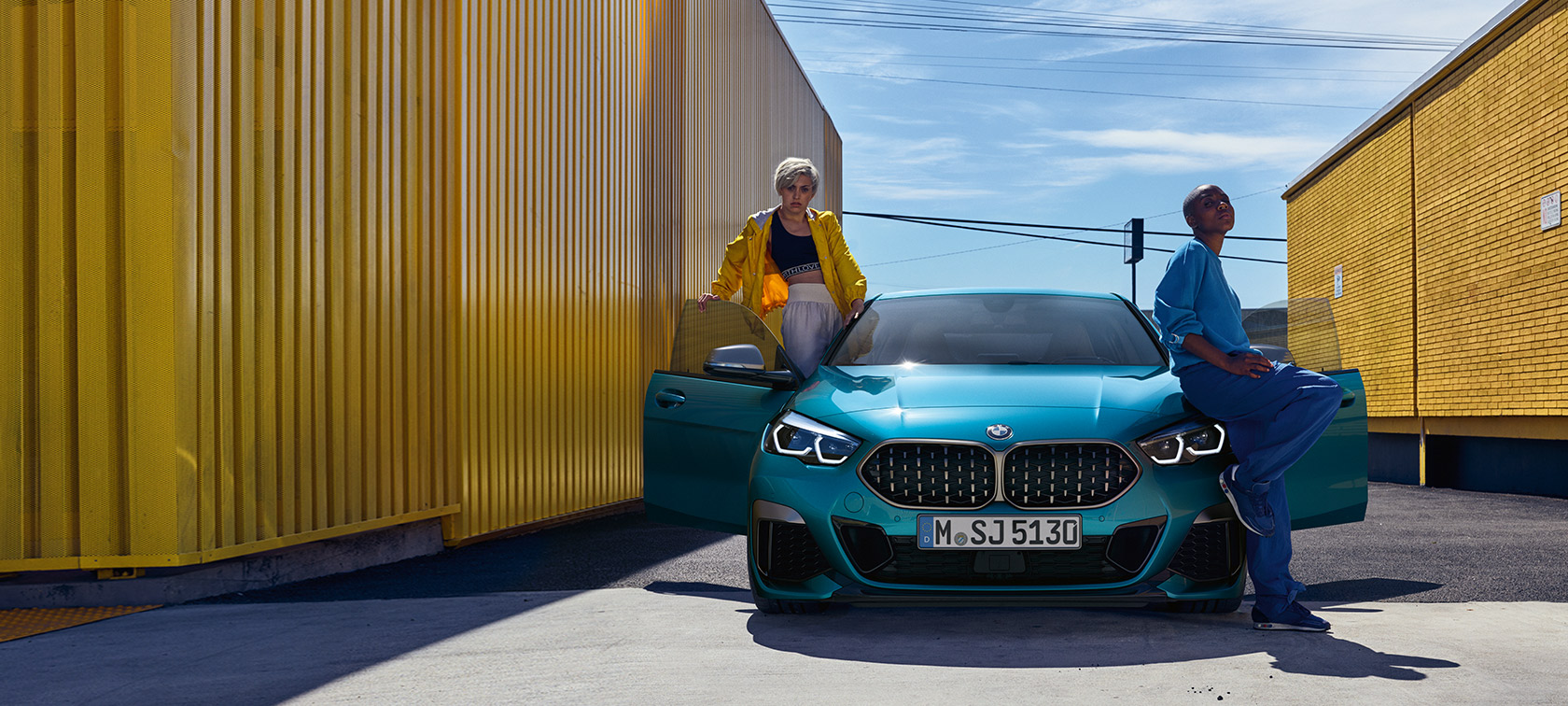 BMW 2er Gran Coupé F44, Frontansicht BMW 2er Gran Coupé F44 Snapper Rocks Blau metallic, Frontansicht mit geöffneten Türen und zwei Personen am Fahrzeug