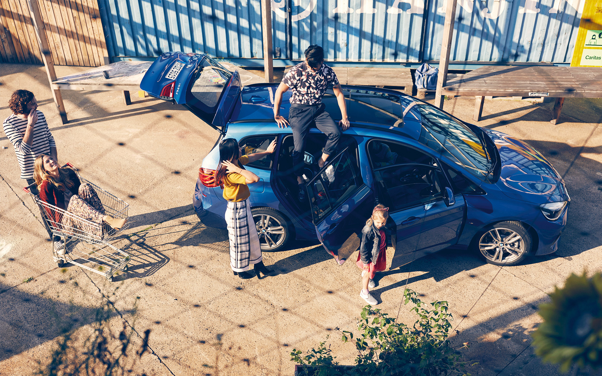 Eine Familie bei der Rast von der Fahrt in einem blauen BMW 2er Gran Tourer Eine Familie bei der Rast von der Fahrt in einem blauen BMW 2er Gran Tourer