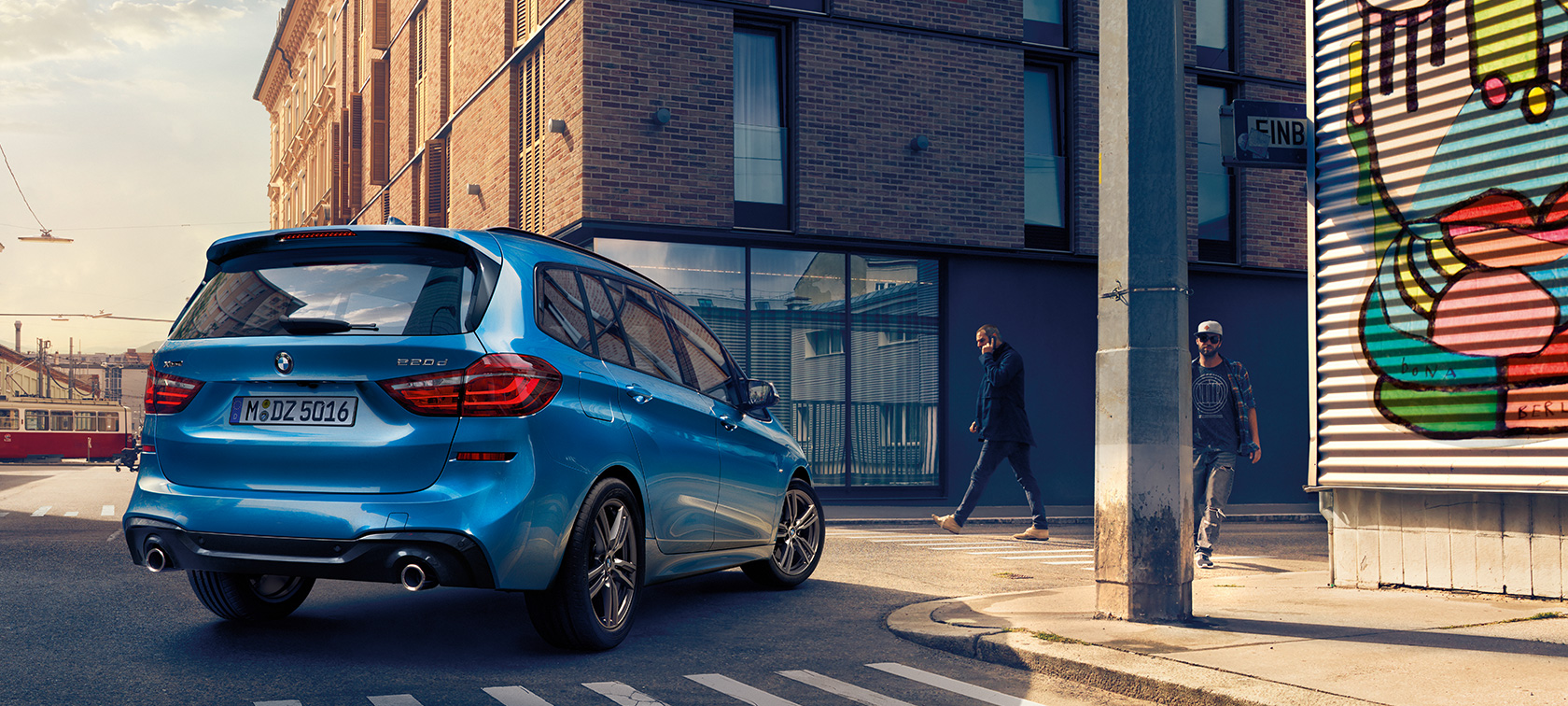 BMW 2er Gran Tourer in der Vogelperspektive F46 Mann neben BMW 2er Gran Tourer F46 Facelift 2018 Misano Blaumetallic Vogelperspektive parkend auf Straße