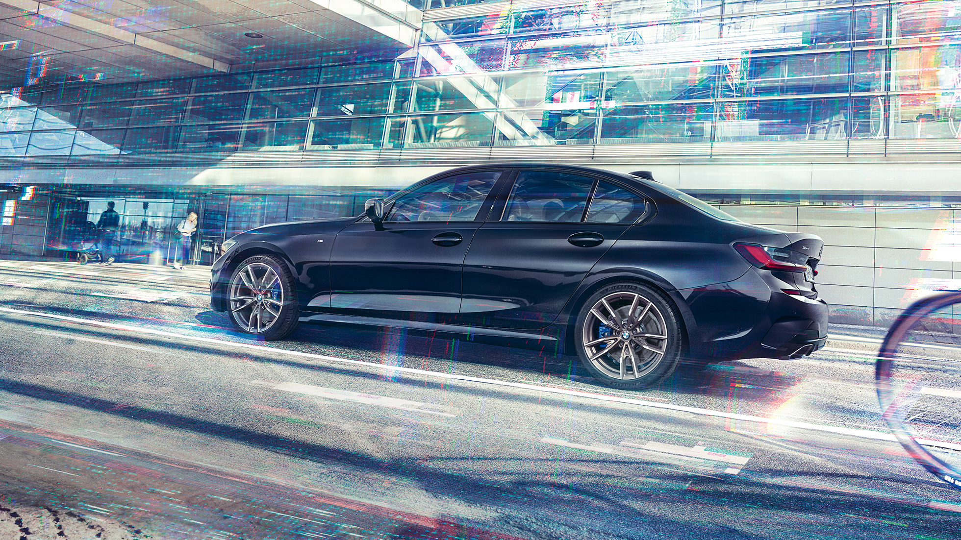 BMW 3er Limousine, BMW M340i xDrive. Seitenansicht des BMW M340i xDrive im Stand vor urbanem Gebäude.