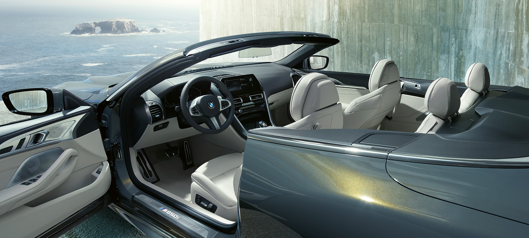 BMW M850i xDrive Dravitgrau metallic, Seitenansicht, Stoffverdeck und Tür geöffnet. BMW M850i xDrive Dravitgrau metallic, Seitenansicht, Stoffverdeck und Tür geöffnet.