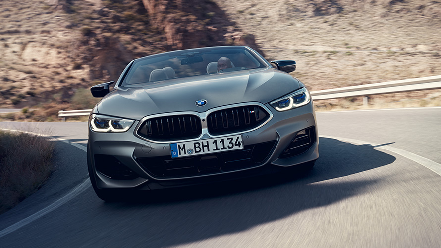 BMW 8er Cabriolet M Sportpaket G14 LCI Facelift 2022 Frontansicht fahrend durch Kurve BMW 8er Cabrio M Sportpaket G14 LCI Facelift 2022 BMW Individual Frozen Pure Grey metallic Frontansicht fahrend durch Kurve