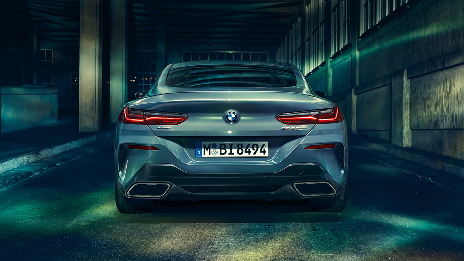 BMW 8er Coupé, Heckansicht Heckansicht des BMW 8er Coupé in der Nacht vor urbaner Kulisse.