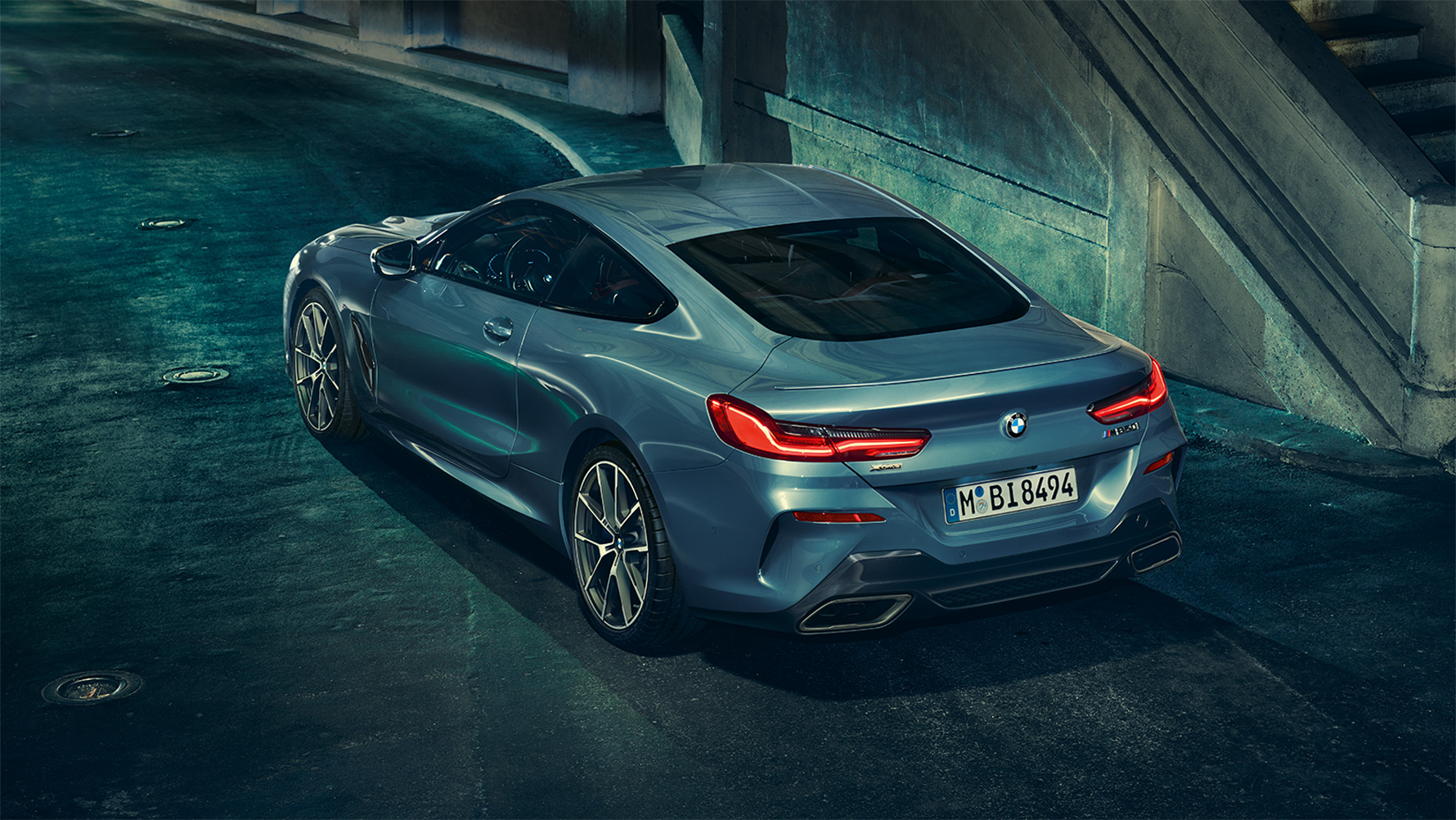 BMW 8er Coupé, Dreiviertel-Heckschuss Dreiviertel-Heckschuss des BMW 8er Coupé in der Nacht vor urbaner Kulisse.