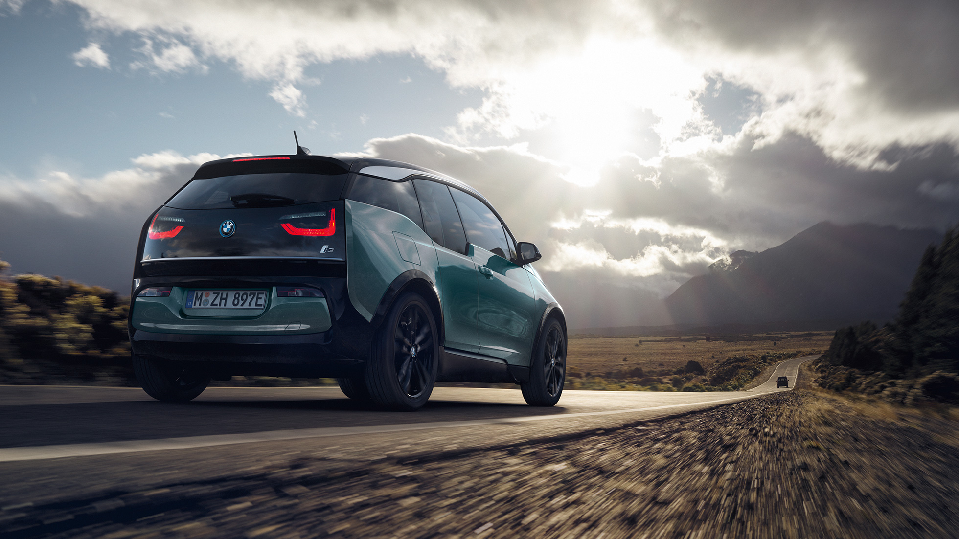 BMW i3 2018 Dreiviertel-Heckansicht fahrend auf Landstraße BMW i3 I01 2018 Jucarobeige mit Akzent Frozen Grey metallic Dreiviertel-Heckansicht fahrend auf Landstraße