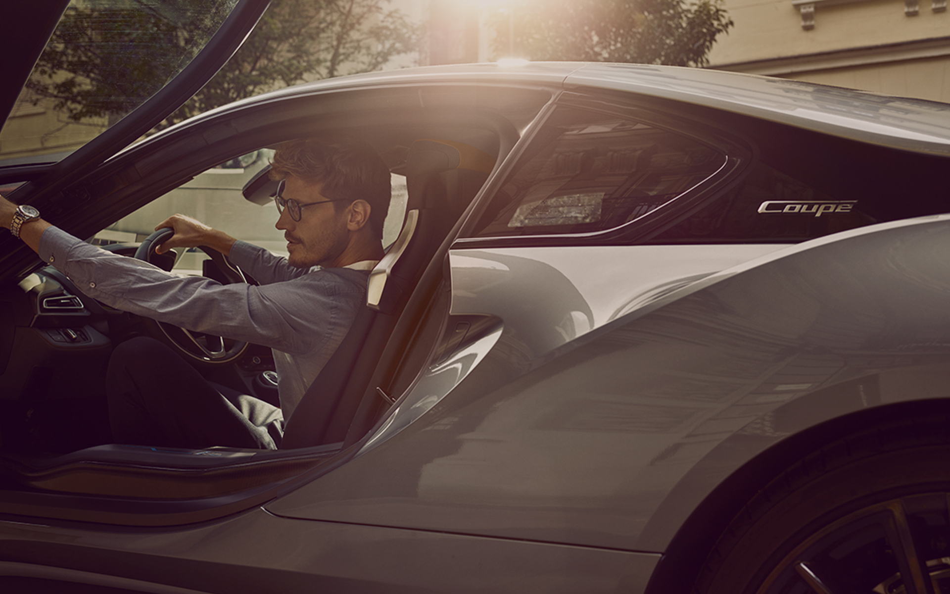 Junger Mann beim Aussteigen aus seinem BMW i8 Coupé Junger Mann beim Aussteigen aus seinem BMW i8 Coupé