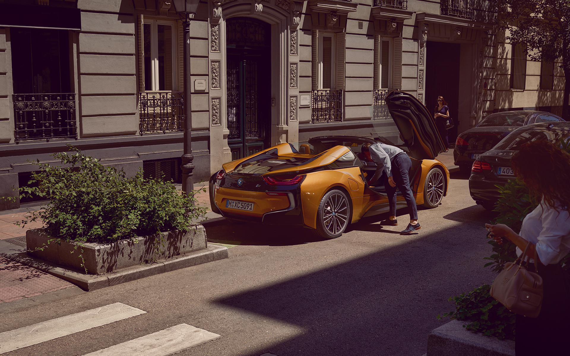Junger Mann greift in den Fußraum seines geparkten BMW i8 Roadster Junger Mann greift in den Fußraum seines geparkten BMW i8 Roadster