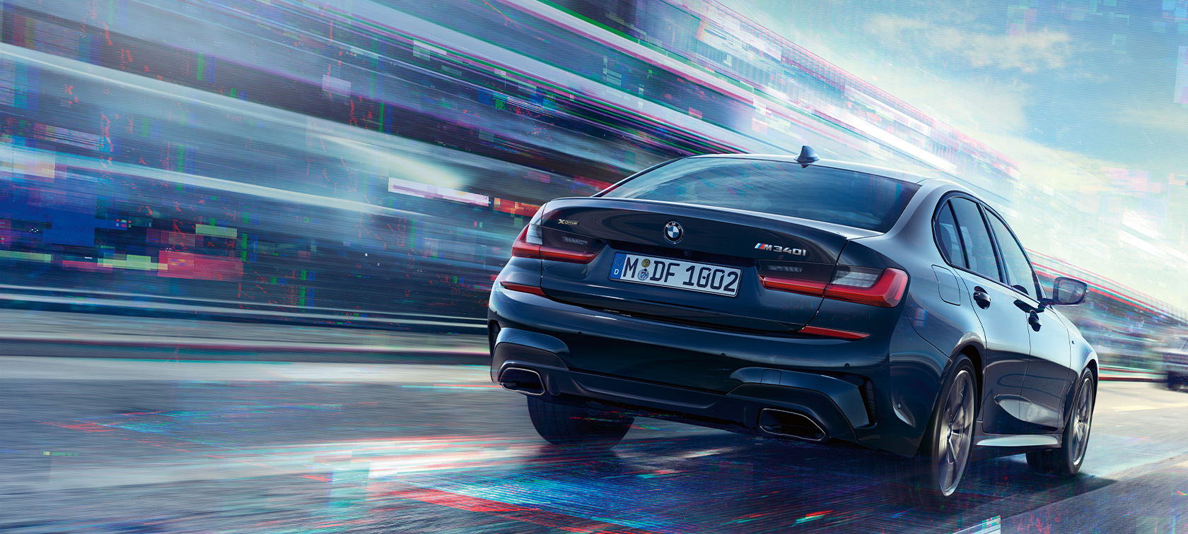 Heckansicht BMW M340i xDrive Limousine BMW M340i xDrive Limousine G20 Saphirschwarz metallic Heckansicht bei Fahrt