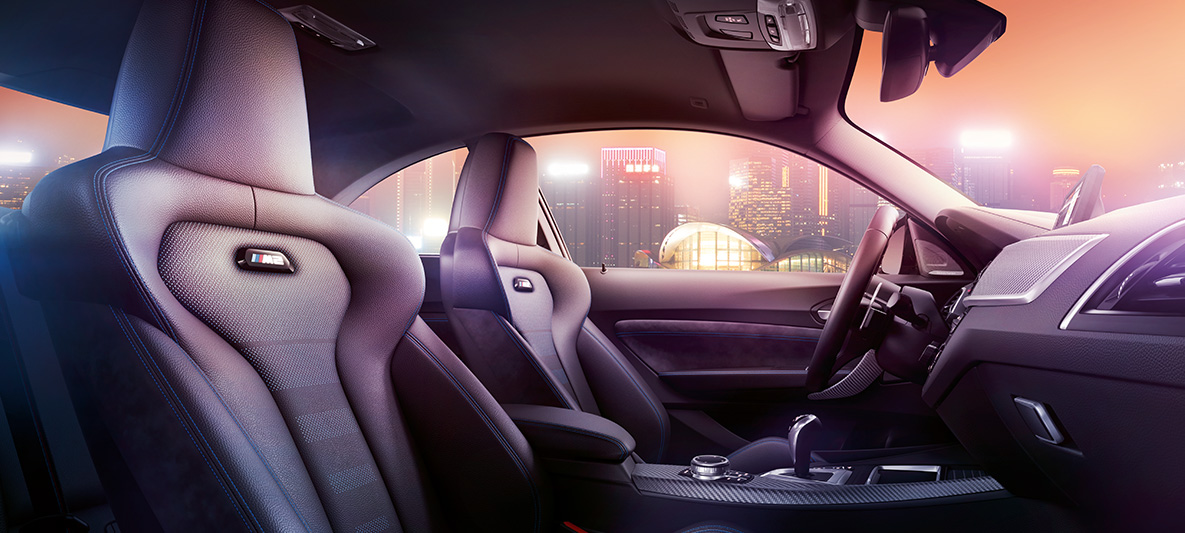BMW M2 Competition Sportsitze Cockpit und M Sportsitze des BMW M2 Competition, nächtliche Skyline im Hintergrund.
