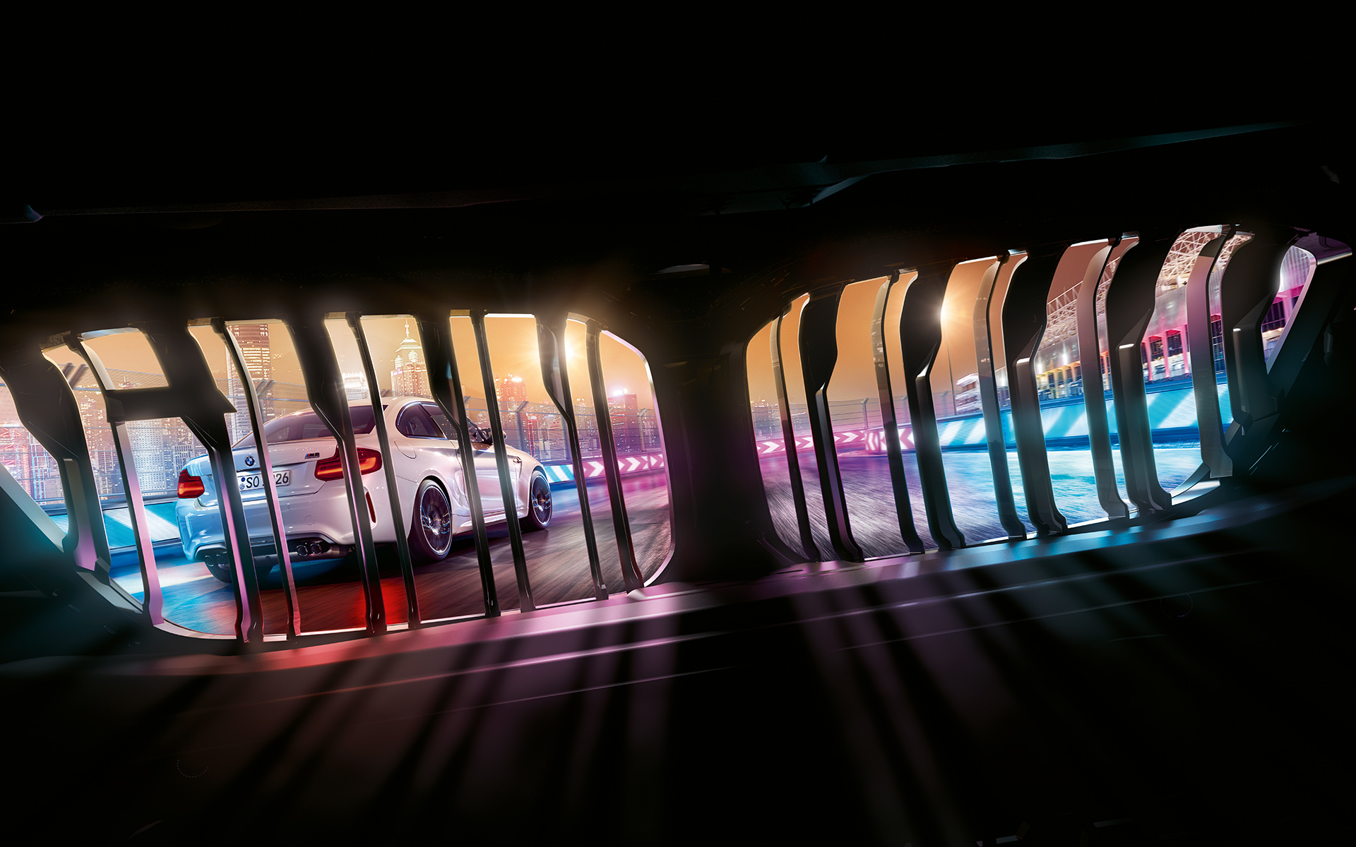 BMW M2 Competition Niere Blick durch BMW Niere auf vorausfahrenden BMW M2 Competition auf nächtlicher Rennstrecke.
