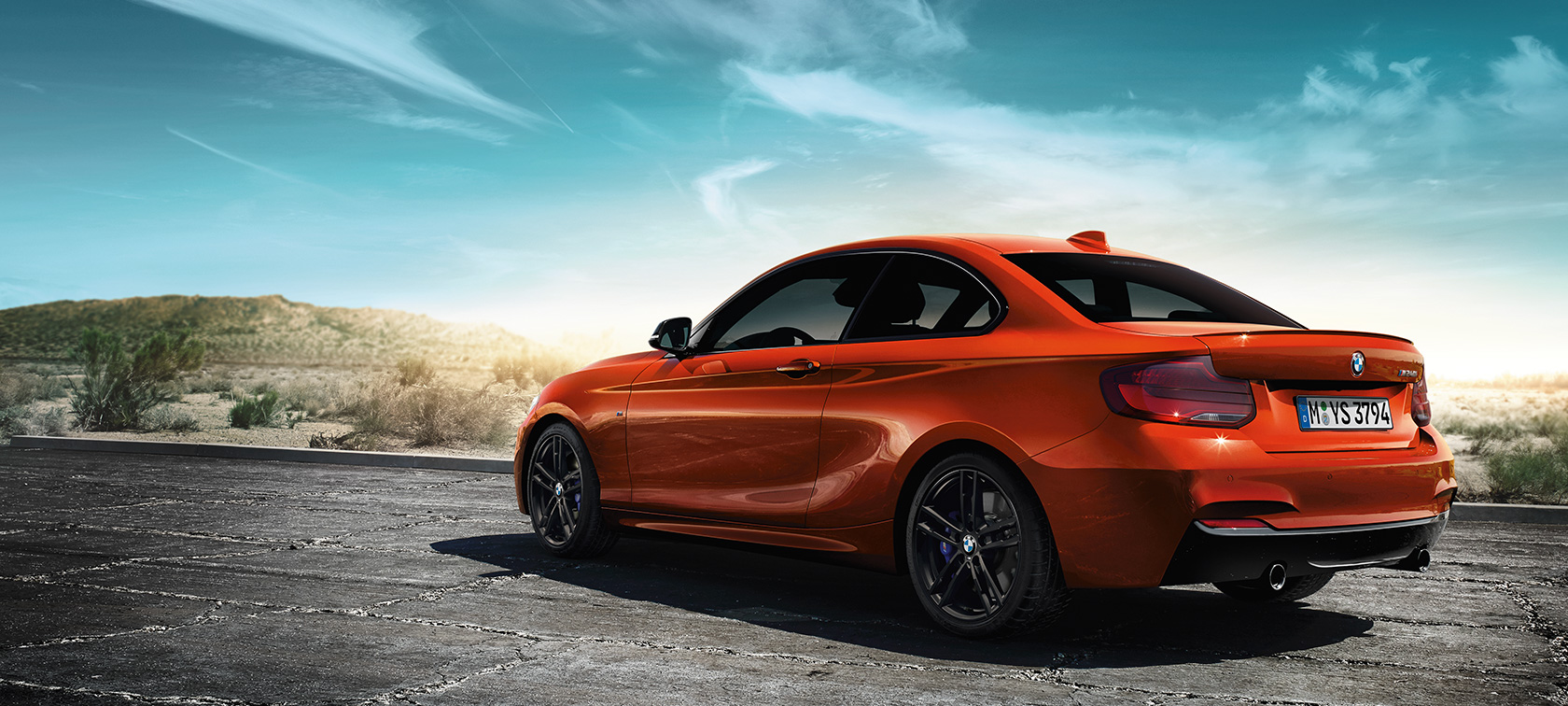 BMW M240i Coupé F22 Dreiviertel-Heckansicht stehend BMW M240i Coupé F22 2017 Sunset Orange metallic Dreiviertel-Heckansicht stehend vor Steppenlandschaft