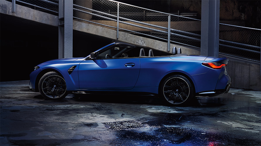 BMW M4 Competition Cabrio mit M xDrive G83 2021 Frozen Portimao Blau metallic Seitenansicht mit geöffnetem Verdeck