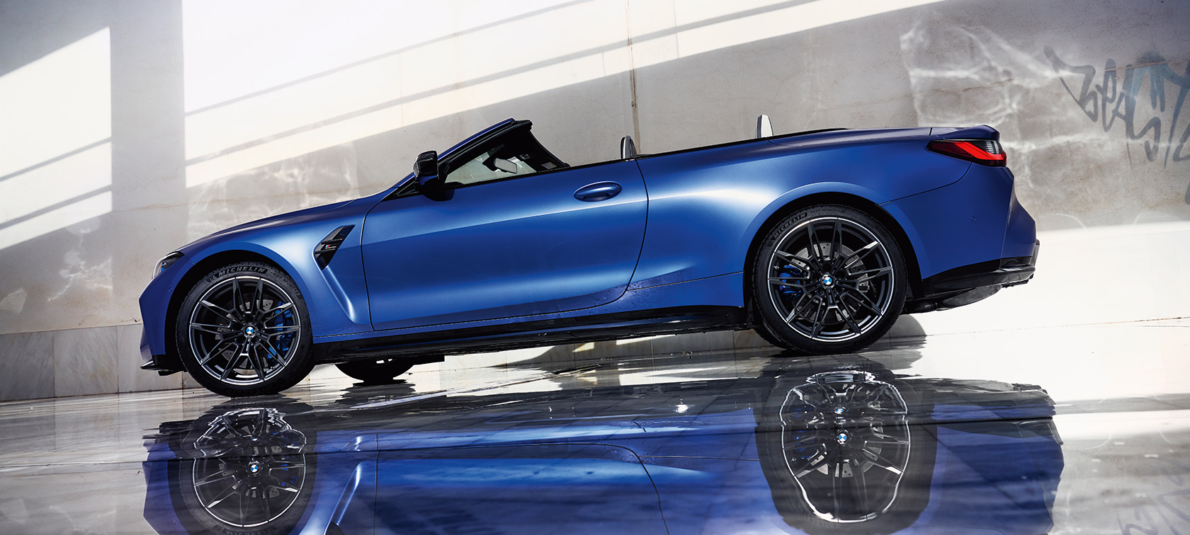 BMW M4 Competition Cabrio mit M xDrive G83 2021 BMW Individual Frozen Portimao Blau metallic Seitenansicht stehend Froschperspektive