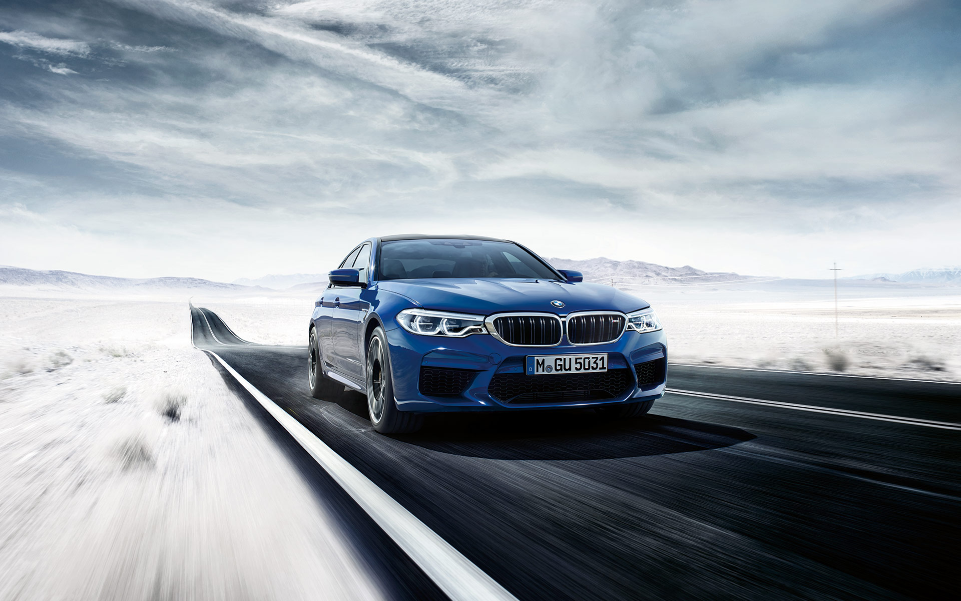 BMW M5 fährt auf der Straße in einer Schneelandschaft, Vorderansicht BMW M5 fährt auf der Straße in einer Schneelandschaft, Vorderansicht