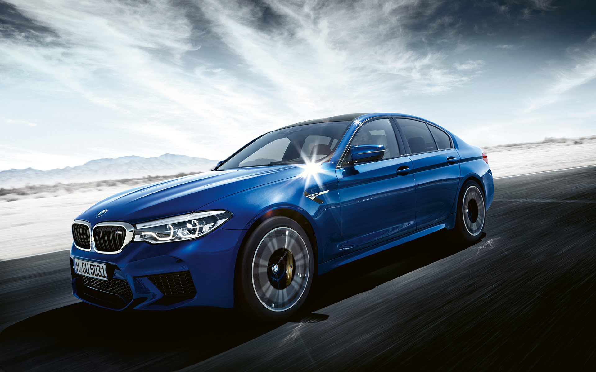 BMW M5 fährt auf der Straße in einer Schneelandschaft, Seitenansicht BMW M5 fährt auf der Straße in einer Schneelandschaft, Seitenansicht
