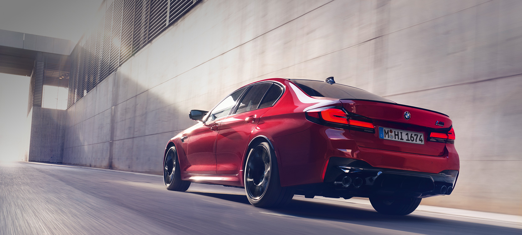 BMW M5 Competition F90 LCI Facelift 2020 Dreiviertel-Heckansicht fahrend BMW M5 Competition F90 LCI Facelift 2020 BMW Individual Imola Rot Dreiviertel-Heckansicht fahrend
