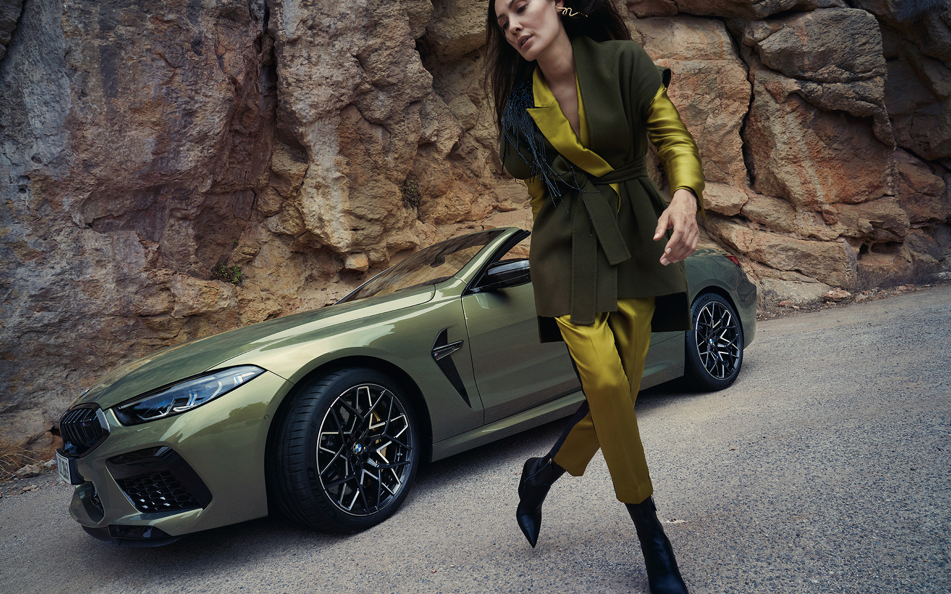 BMW M8 Competition Cabriolet F91 LCI Facelift 2022 BMW Individual Brass metallic Dreiviertel-Frontansicht stehend in steinigem Gelände mit weiblichem Model