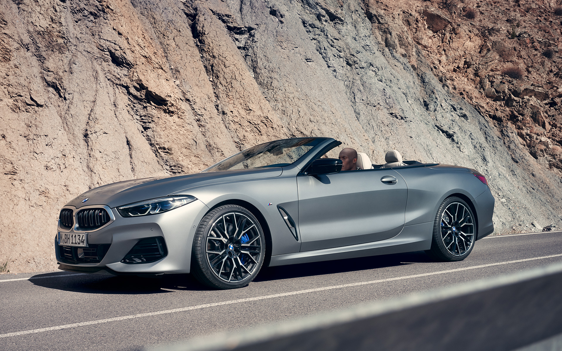BMW M850i xDrive Cabriolet G14 LCI Facelift 2022 BMW Individual Frozen Pure Grey metallic Dreiviertel-Frontansicht fahrend vor Felswand