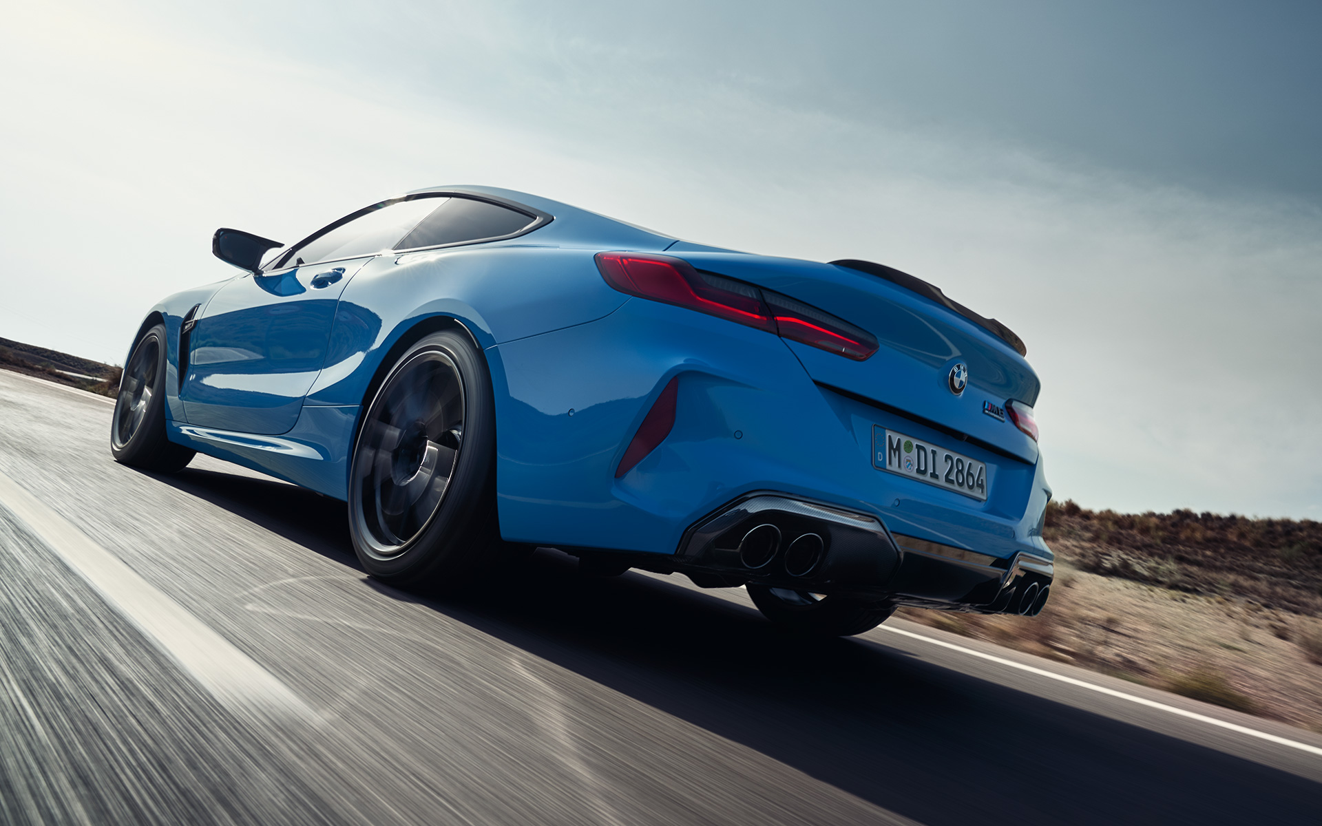 BMW M8 Competition Coupé F92 LCI Facelift 2022 Daytona Beach Blau uni Dreiviertel-Heckansicht fahrend auf Landstraße
