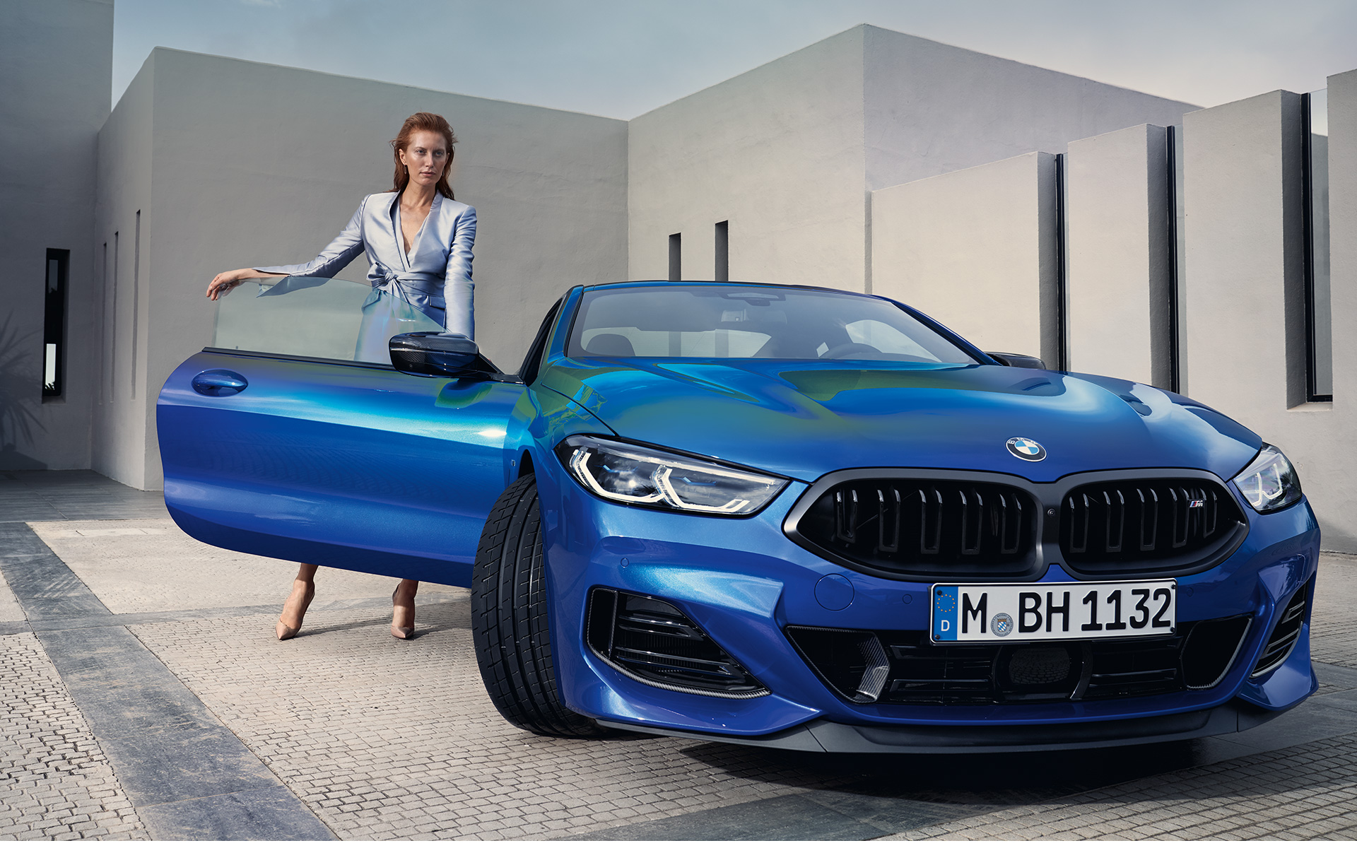 BMW M850i xDrive Coupé G15 LCI Facelift 2022 M Portimao Blau metallic Frontansicht stehend mit weiblichem Model in geöffneter Beifahrertür