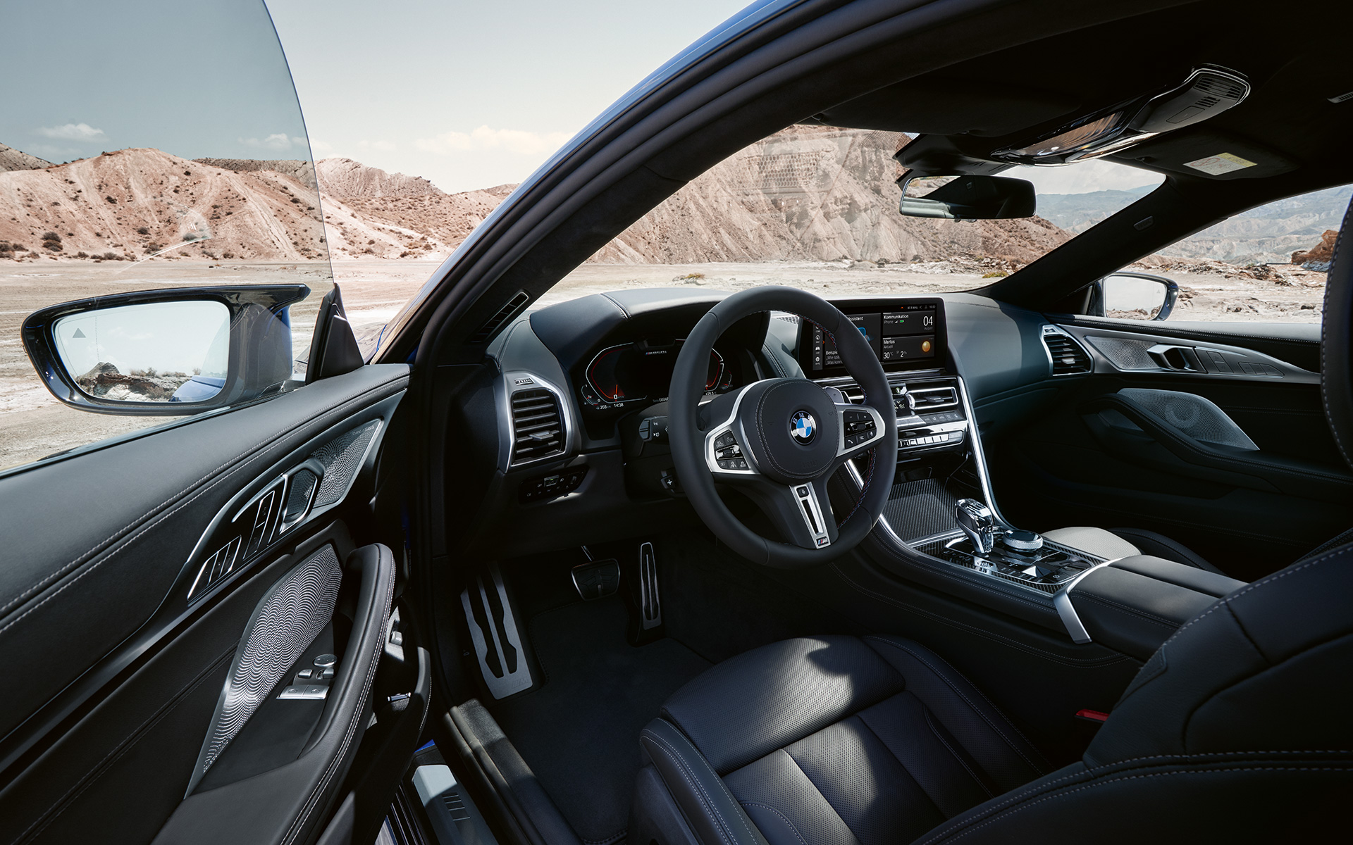 BMW M850i xDrive Coupé G15 LCI Facelift 2022 fahrerorientiertes Cockpit mit M Lederlenkrad bei geöffneter Fahrertür