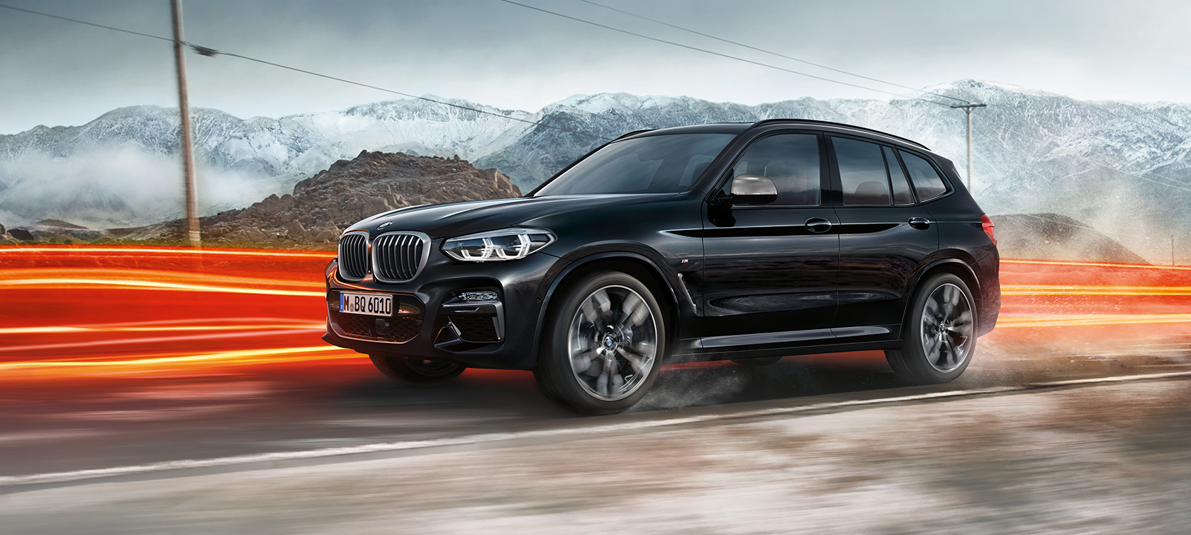 BMW X3 M40i und BMW X3 M40d SUV, Seitenansicht F97. BMW X3 M40i und BMW X3 M40d SUV in Saphirschwarz metallic, fahrend, Exterieur, Seitenansicht vor Berglandschaft mit Lichtstreifen F97.