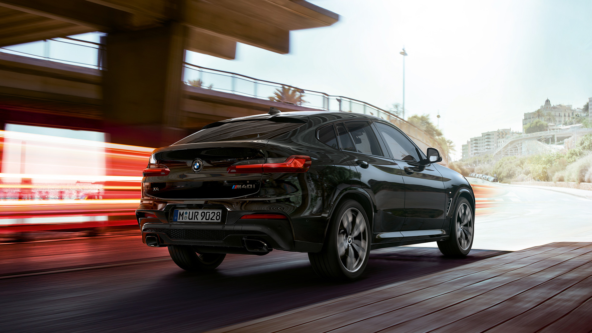 BMW X4 M40i, Dreiviertel-Frontansicht. BMW X4 M40i in Saphirschwarz metallic, fahrend, Exterieur, Dreiviertel-Frontansicht mit Lichtstreifen.