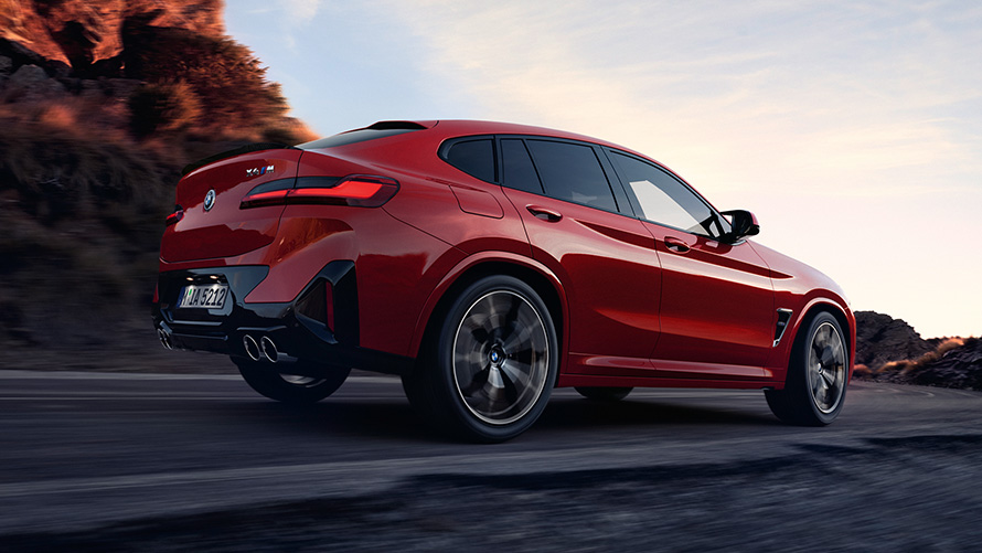 BMW X4 M F98 LCI Facelift 2021 Toronto Rot metallic Dreiviertel-Heckansicht fahrend auf der Straße