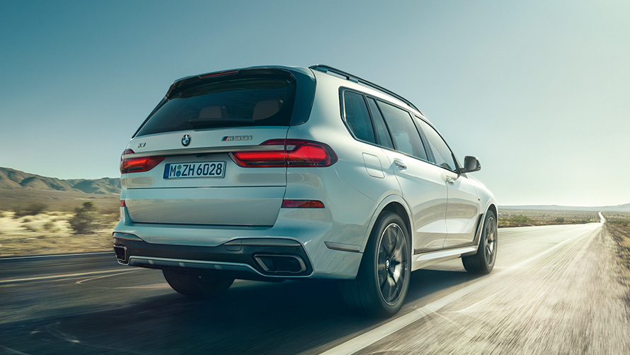 BMW X7 M50i G07 2019 Mineralweiß Heckansicht fahrend BMW X7 M50i G07 2019 Mineralweiß Heckansicht fahrend