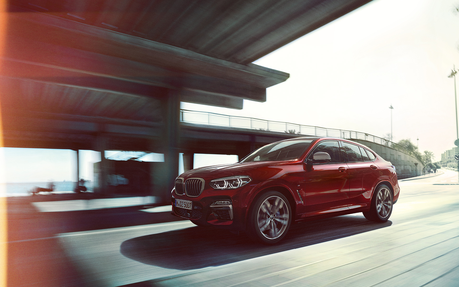 Roter BMW X4 fährt entlang einer Straße Roter BMW X4 fährt entlang einer Straße