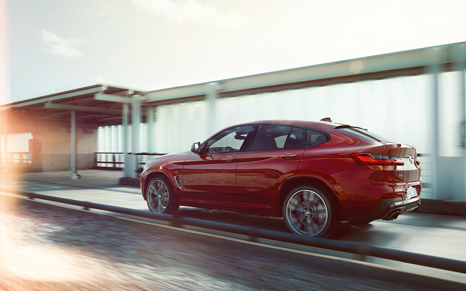 BMW X4 fährt an einer Straße entlang, Seitenansicht BMW X4 fährt an einer Straße entlang, Seitenansicht