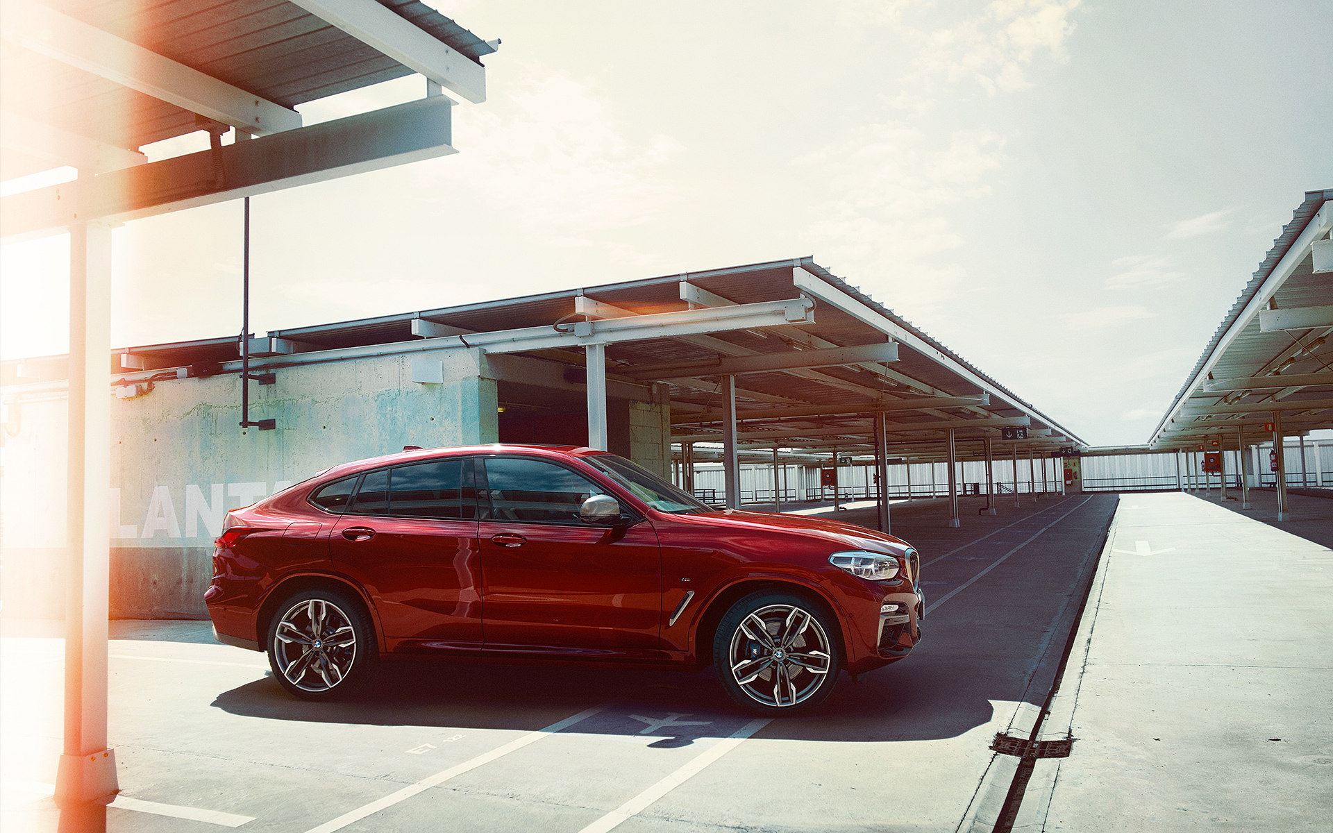 Roter BMW X4 von der Seite auf einem Parkplatz Roter BMW X4 von der Seite auf einem Parkplatz
