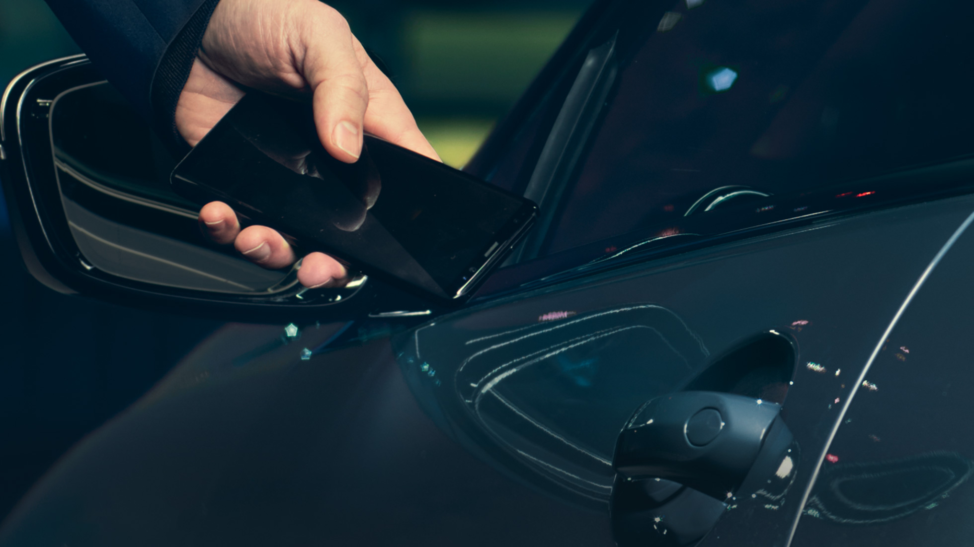 Digital Key Digital Key: Mann hält sein Smartphone von außen an die Fahrzeugtür