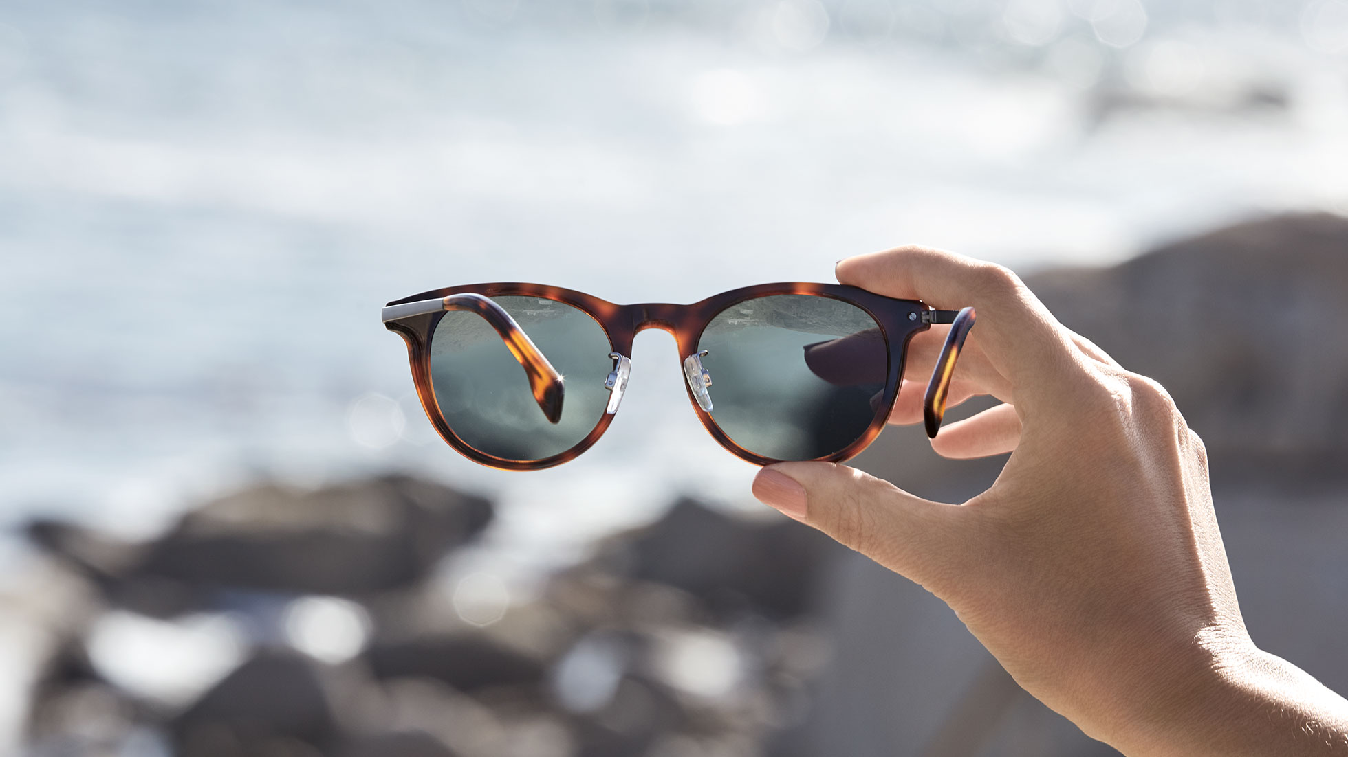 Immer im Fokus bleiben: die BMW Sonnenbrille Damen und Herren. Eine Hand hält die BMW Sonnenbrille Damen und Herren in das Zentrum des Bildes.