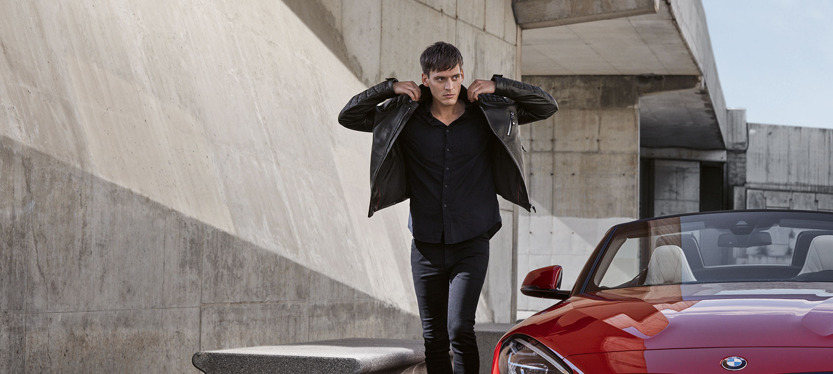 Im Bild läuft ein junger Herr dem Betrachter entgegen und präsentiert dabei Produkte einer Kollektion von BMW Lifestyle Herren. Im Bild läuft ein junger Herr dem Betrachter entgegen und präsentiert dabei Produkte einer Kollektion von BMW Lifestyle Herren.