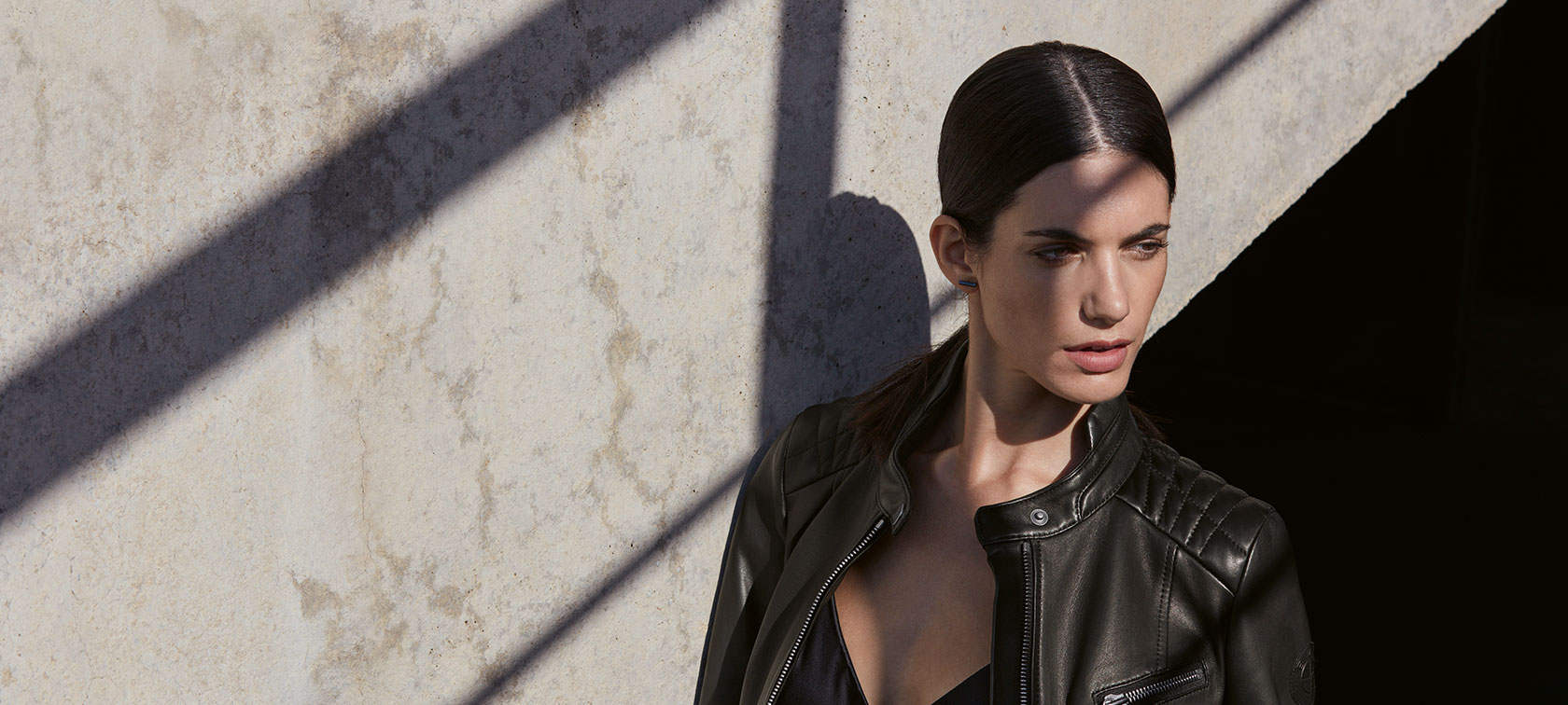 Defining Life and Style. Auf dem Bild trägt eine junge Frau die BMW Lederjacke für Damen vor einer urbanen Kulisse.
