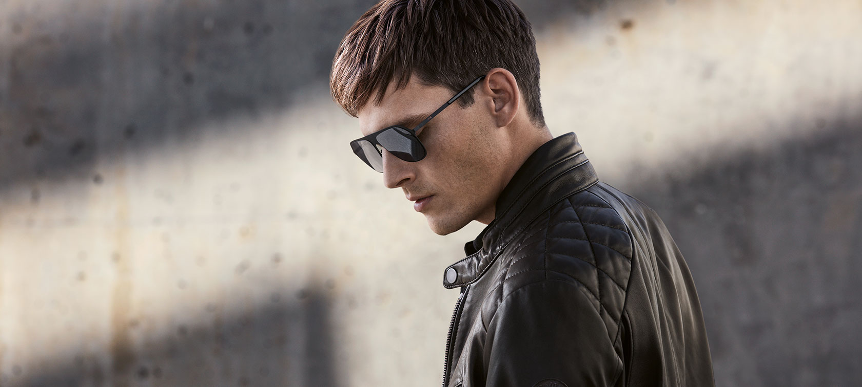 Nach unten blickendes Model trägt Sonnenbrille und die BMW Lederjacke für Herren. Nach unten blickendes Model trägt Sonnenbrille und die BMW Lederjacke für Herren.