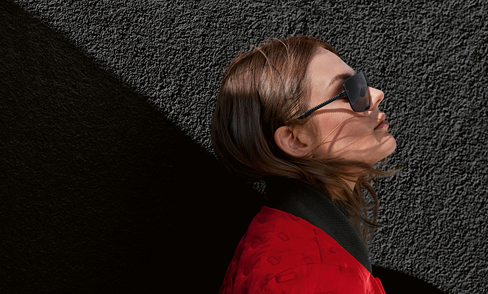 BMW M Jacket für Damen und BMW M Sonnenbrille. Eine junge Frau trägt die BMW M Jacke Damen und die BMW M Sonnenbrille.