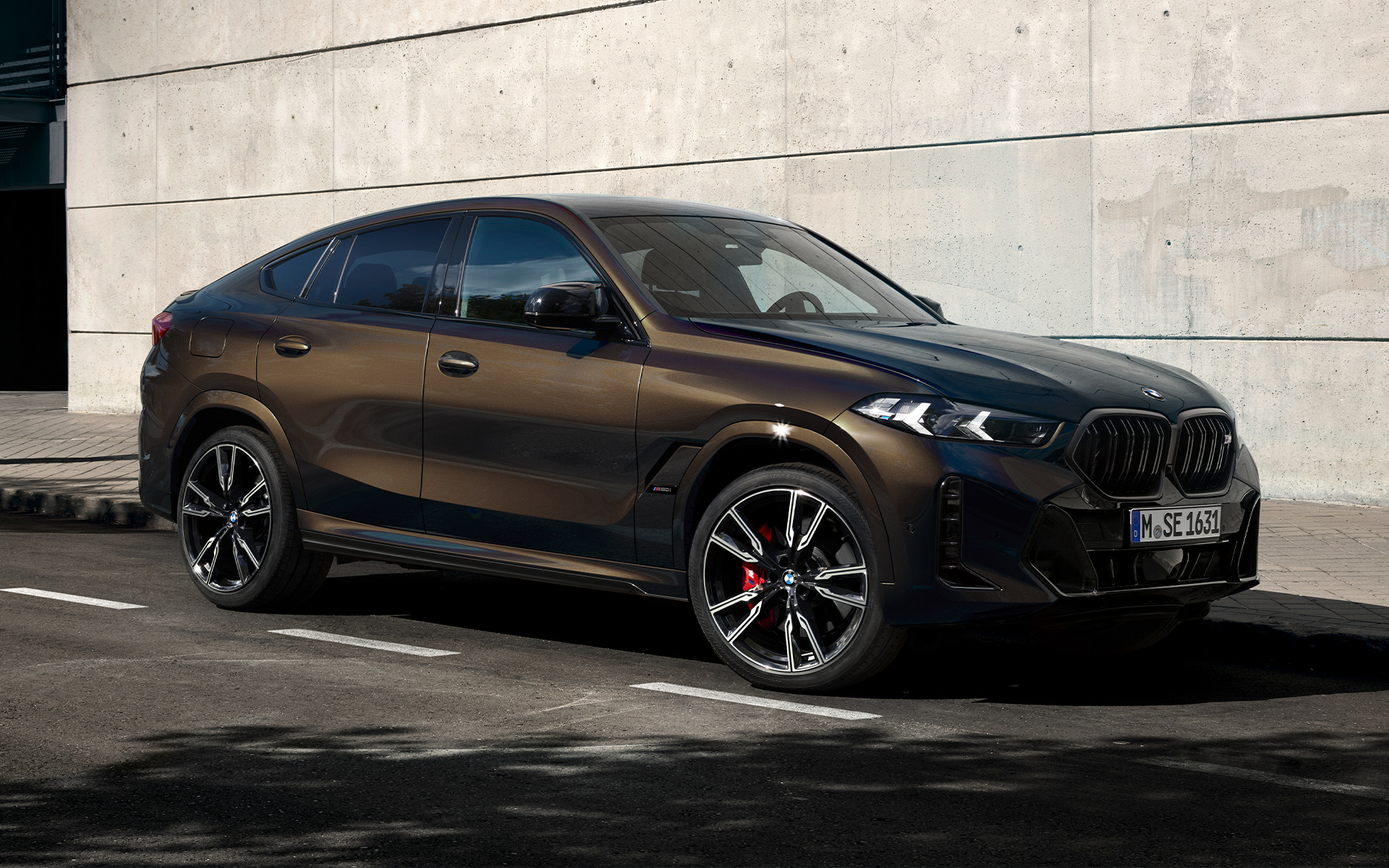 BMW X6 M60i G06 in BMW Individual Pyritbraun metallic, 2/3 Seitenansicht, parkend in Parkbucht