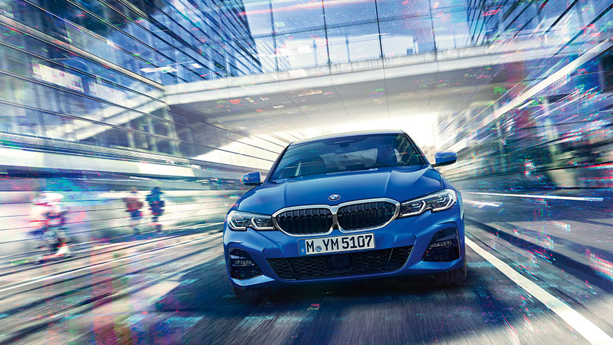 Fahraufnahme eines blauen BMW Fahraufnahme eines blauen BMW mit Glasüberführung im Hintergrund
