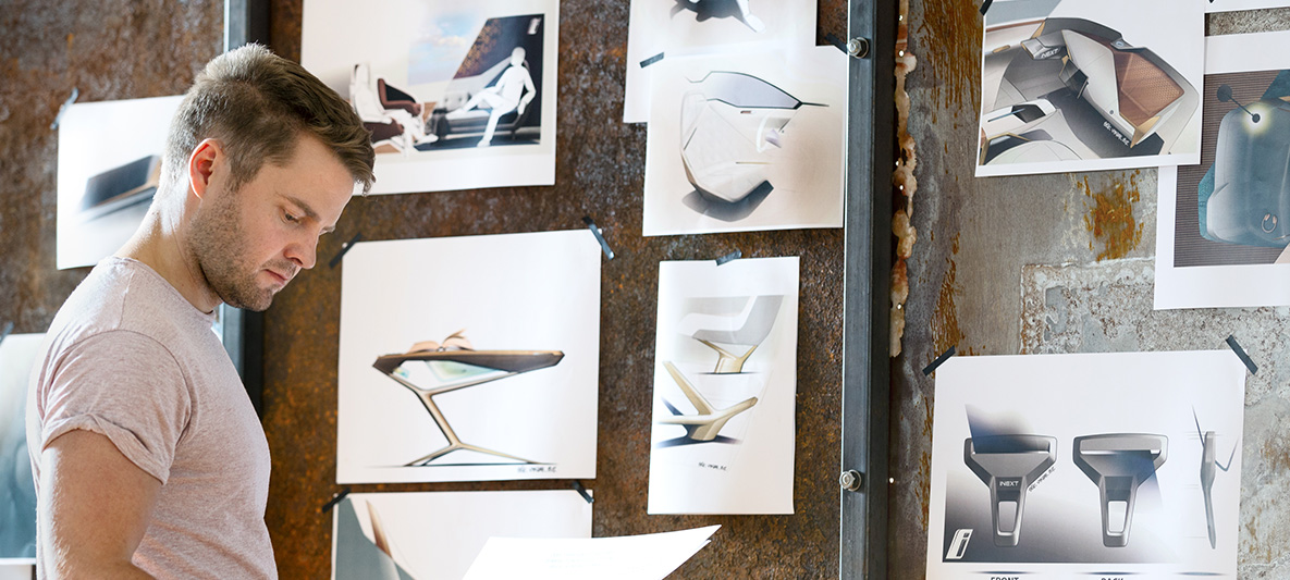 Entwurfsskizzen des BMW Vision iNEXT Mann vor Wand mit Entwurfsskizzen des BMW Vision iNEXT