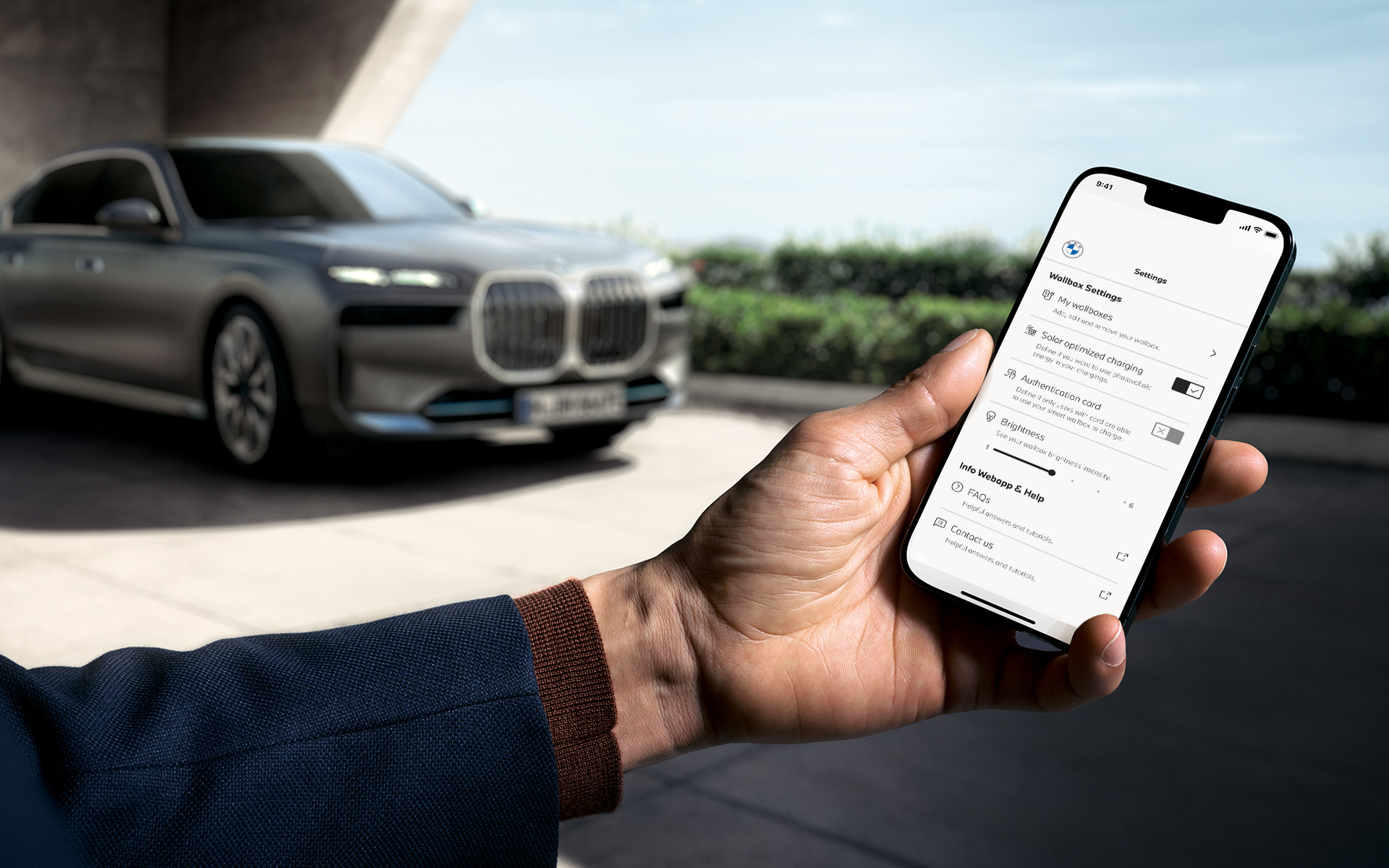 BMW i7 G70 Smartphone im Vordergrund zeigt My BMW App